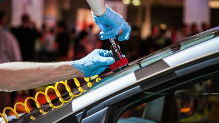 Gloved hands completing windshield repair in Houston